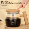 A clear glass mug filled with dark liquid is shown with a wooden handle, demonstrating a one-click automatic stirring device.