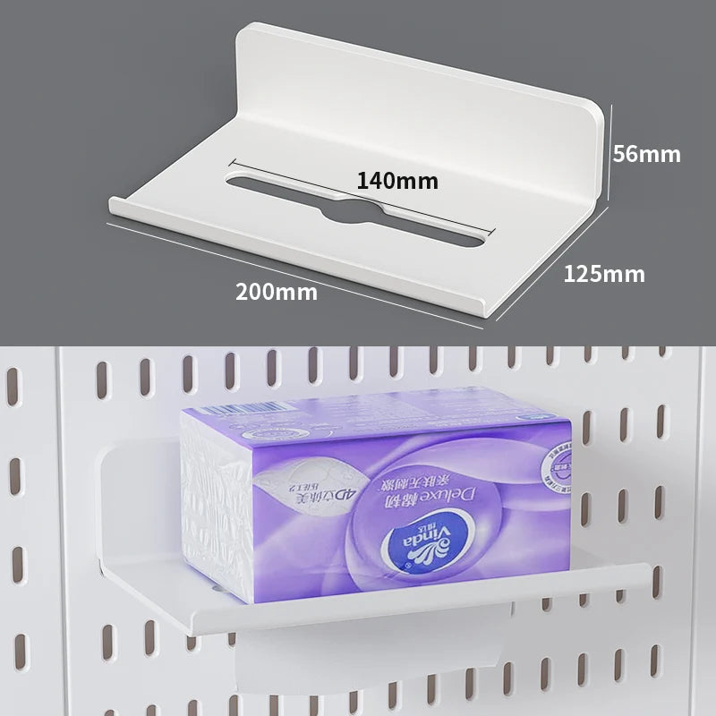 A white modular wall pegboard storage panel with hooks and a shelf is shown in a close-up view.