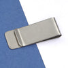 A silver metal tie clip is shown resting on a blue felt background.