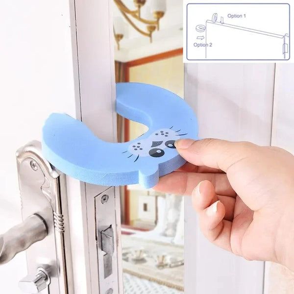 A hand holds a blue animal-shaped door stopper designed for baby safety on a white door frame.