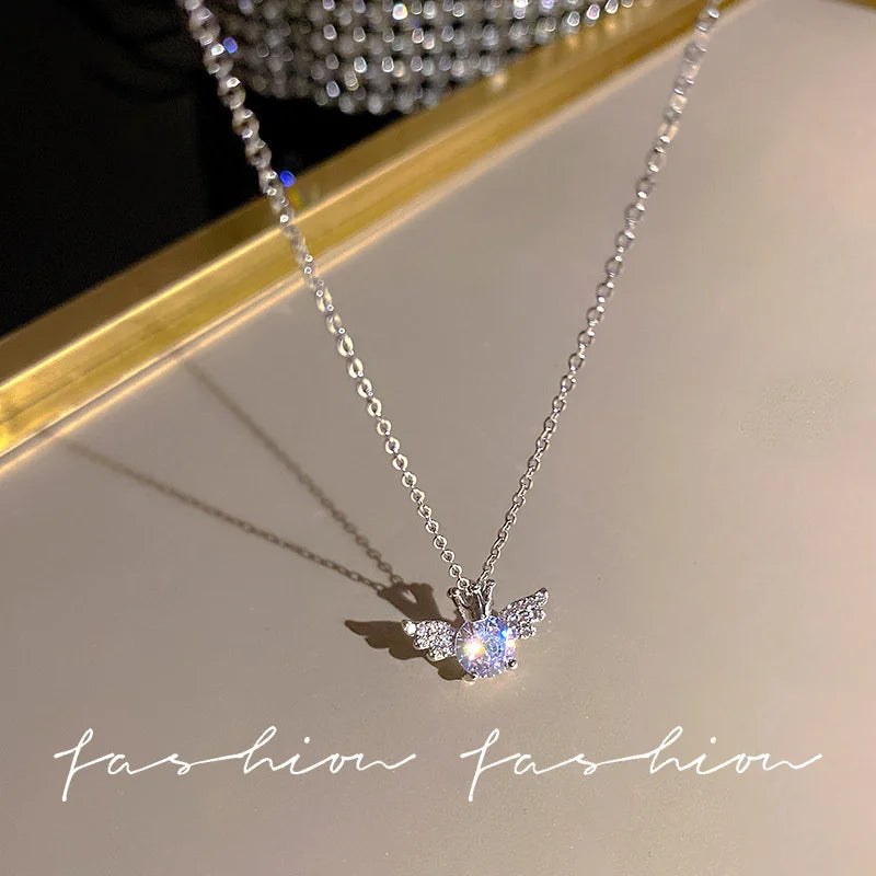 Silver crystal bow angel wings heart pendant necklace displayed on a light background.