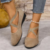 Ein Paar beige Damen-Riemchen-Keil-Loafers im römischen Retro-Stil getragen an einem Fuß.