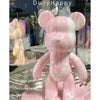 A pink bear figurine painted in a marbled cheese pink and chocolate white design.