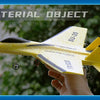 A hand holds a yellow SU-35 remote control fighter plane model with black accents against a blurred green background.