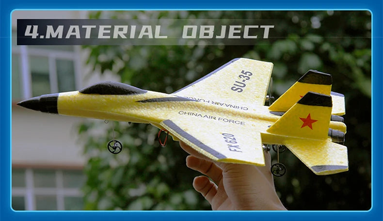 A hand holds a yellow SU-35 remote control fighter plane model with black accents against a blurred green background.