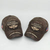 A dark brown vintage washed baseball cap with an embroidered skull and wings design.
