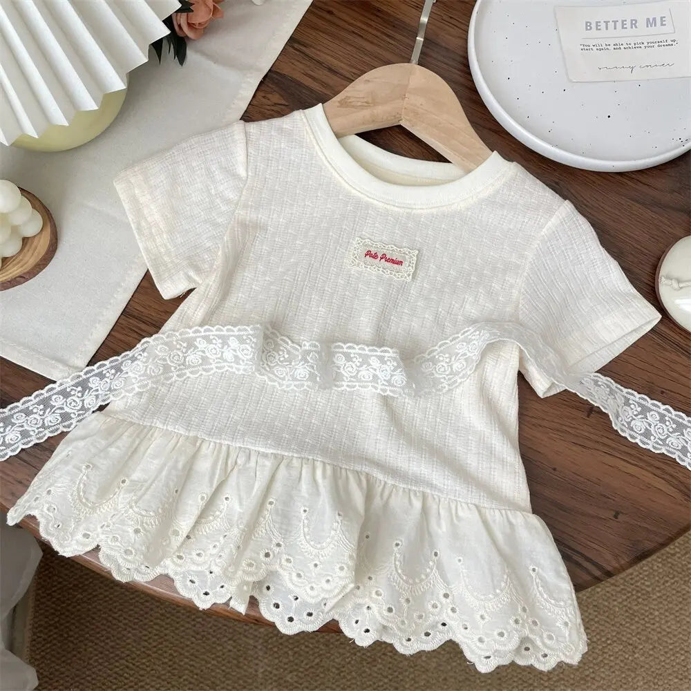 A white girls cotton lace hem short sleeve tee displayed on a wooden hanger.