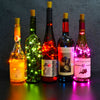 Five glass bottles of Secolul 13 wine illuminated by bright LED fairy lights