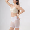 Une femme présente des shorts de sécurité taille haute sans couture de couleur beige clair.