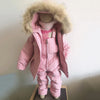 A pink baby winter down jacket and pants set with a faux fur hood displayed on a mannequin.