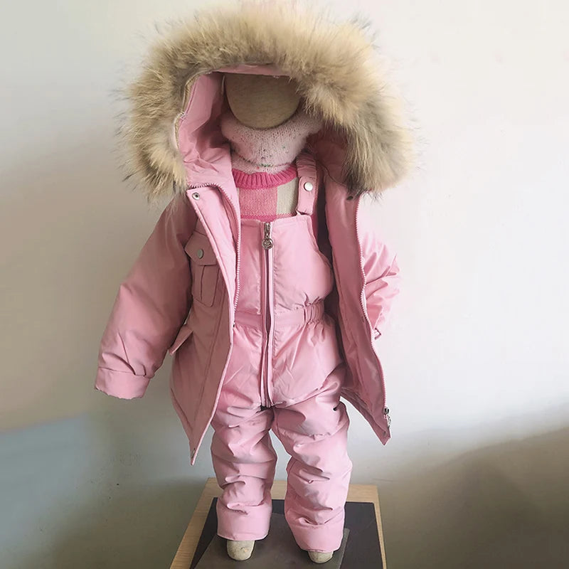 A pink baby winter down jacket and pants set with a faux fur hood displayed on a mannequin.