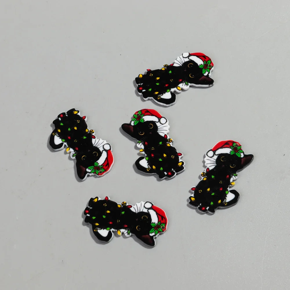 Varios llaveros acrílicos de gato negro con acentos rojos y verdes sobre fondo gris claro.