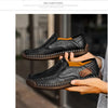 Nærbillede af en mørkebrun læder slip-on loafer, der holdes, med fokus på syning og sål.
