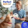 A man is playing with a light-colored dog, holding an interactive squeaky ball toy for dogs.