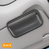 A black PU leather visor sunglasses case with a hook-and-loop strap resting on a light gray car interior surface.