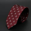 Corbata estampada rojo oscuro con motivos florales blancos, enrollada sobre fondo oscuro.