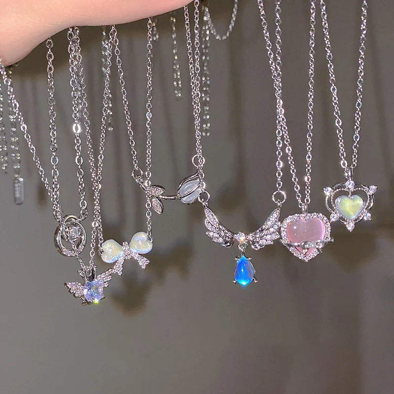 Silver crystal necklace featuring angel wings, heart shapes, and various colored gemstones like blue and pink.