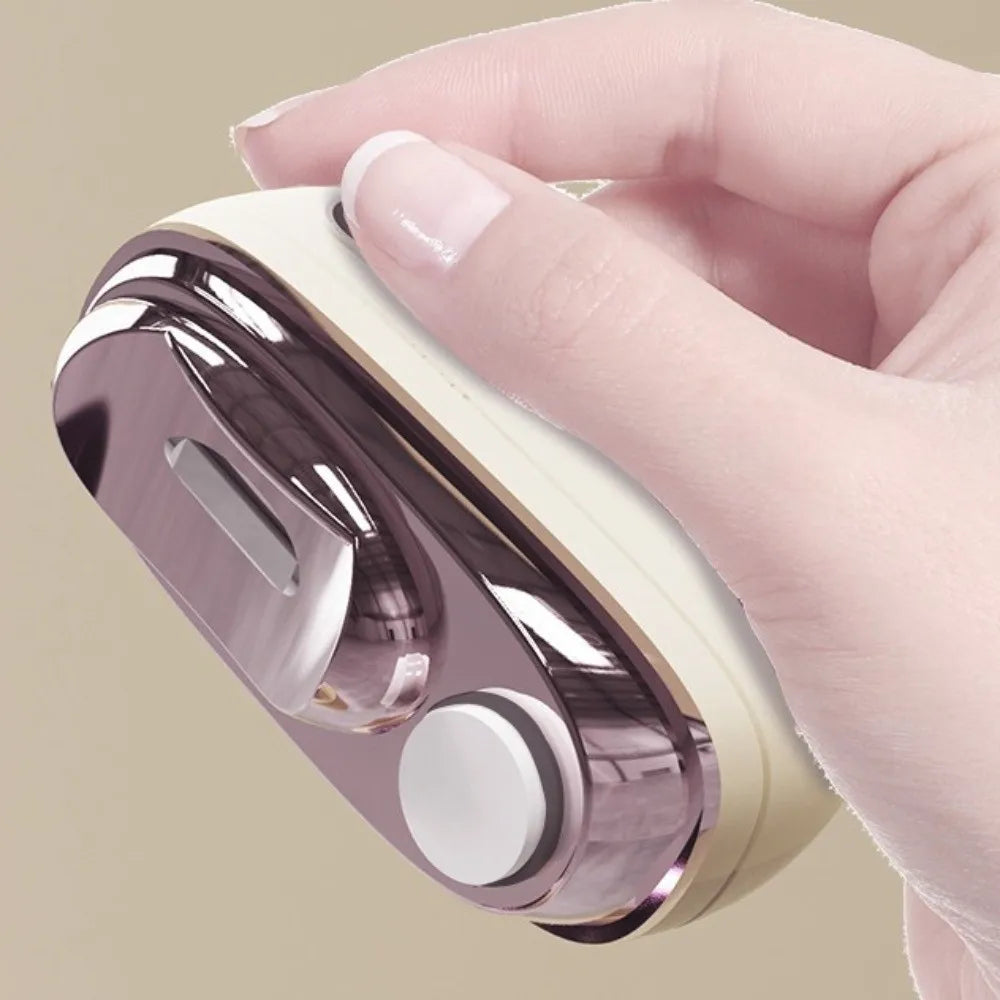 A hand holds a metallic nail clipper and grinder device with a light beige casing and silver accents.