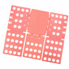 A pink clothes folding board with multiple compartments and circular holes for organizing laundry.