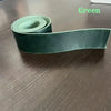 A dark green handcrafted crazy horse leather belt strap rolled up on a wooden surface.