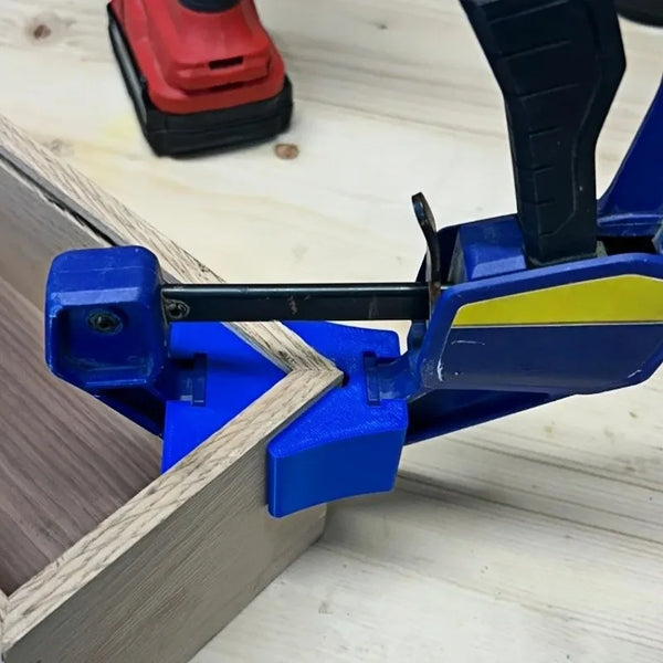 A blue quick clamp angle adapter is shown clamping a piece of light wood on a white surface.