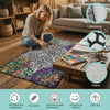 A child is coloring on a large fabric blanket with various art supplies in a cozy living room setting.