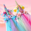 A colorful unicorn mesh headband with pink, purple, and blue accents and floral decorations.