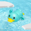 A cute blue duck bath toy floating in clear water with white blocks nearby.