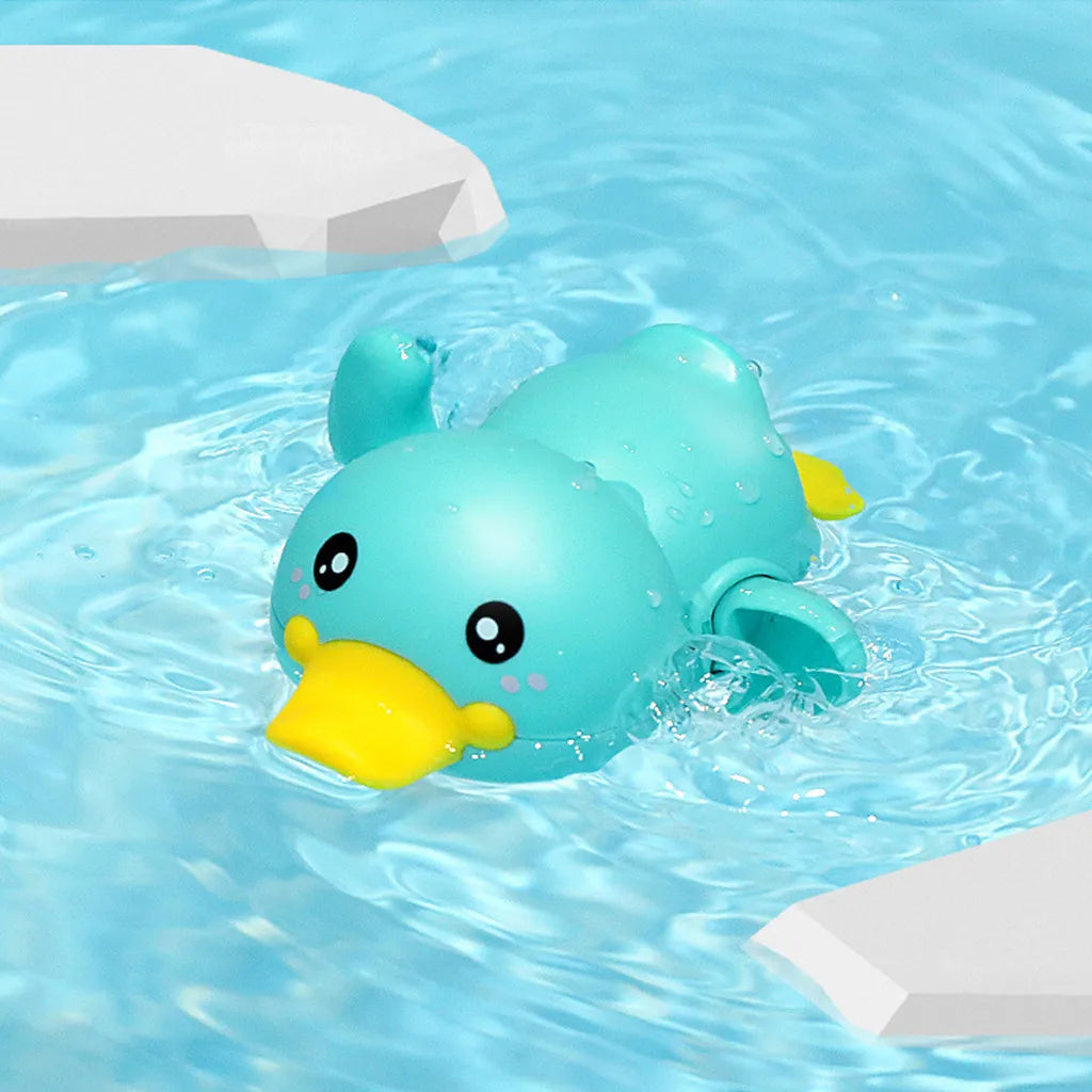 A cute blue duck bath toy floating in clear water with white blocks nearby.