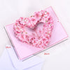 Pink floral wreath heart made of flowers placed on a pink card with dimension lines.