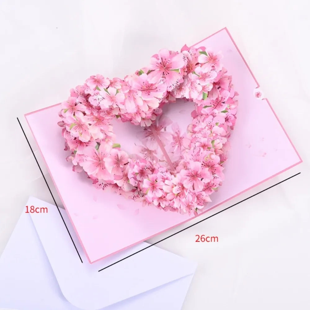 Pink floral wreath heart made of flowers placed on a pink card with dimension lines.