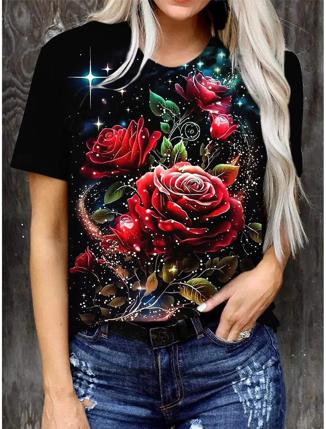 A woman wearing a black t-shirt with a vibrant red rose floral print against a dark background.