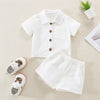 A white cotton linen summer shirt and shorts set for a toddler, laid out on a light background.