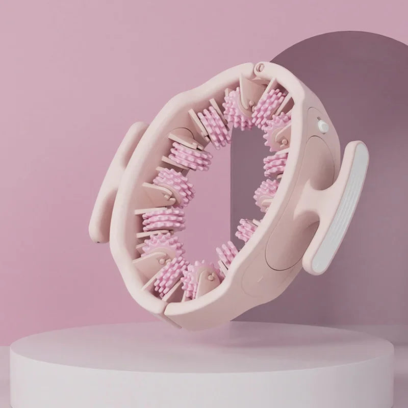 A pink full body massage roller with detachable handles is shown against a light pink background.