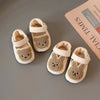 Pair of adorable bear soft-sole sandals for baby's first steps in beige and brown.