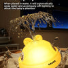 A yellow light-up whale baby bath toy is spraying water in a bathtub.