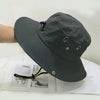 A dark gray men's UV protection wide brim bucket hat is shown resting on a white surface.
