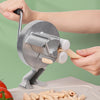 A hand is using a Cavatelli maker machine to roll out fresh pasta strands onto a cutting board.
