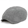 A grey tweed flat cap with a leather label shown from above.