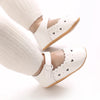 White soft non-slip baby first walker shoes worn on a foot.