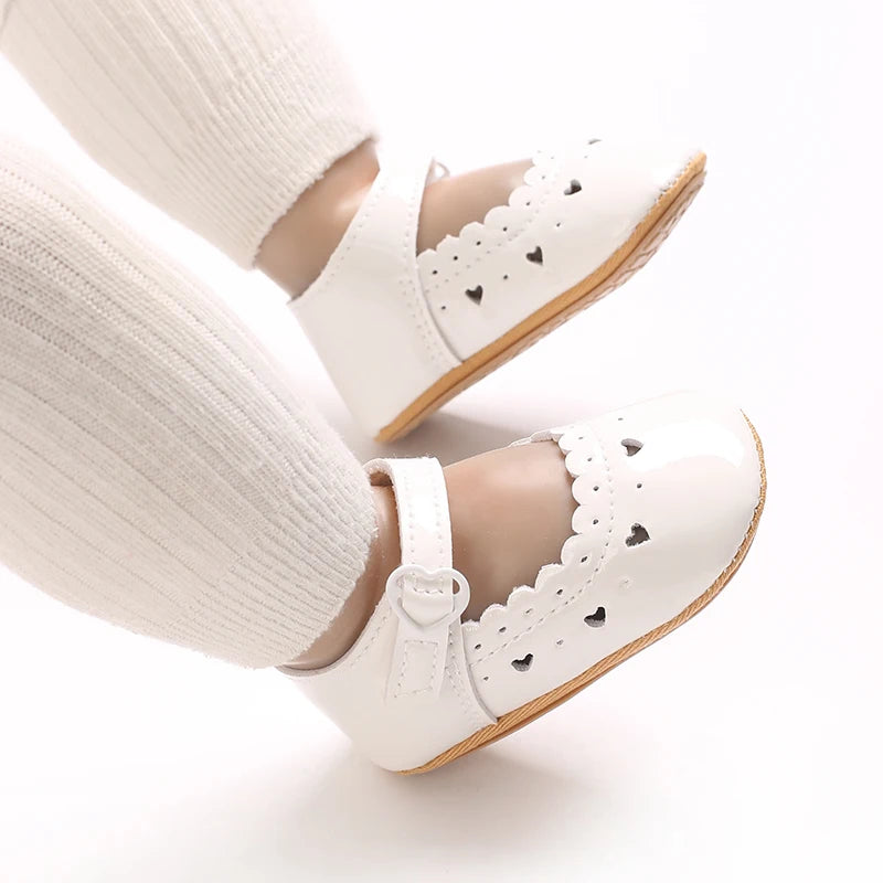 White soft non-slip baby first walker shoes worn on a foot.