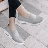 Zapatillas de mujer de cojín de aire en gris claro con suela plataforma gruesa, mostradas en un pie.