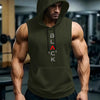 A muscular man wearing a dark olive green hooded tank top and black athletic pants in a gym setting.