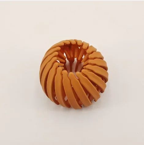 مشبك شعر على شكل عش طائر هندسي بلون بني ذهبي مع تصميم حلزوني