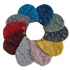 A circular arrangement of women's slouchy knit beanies in various shades of blue, green, red, and gray.