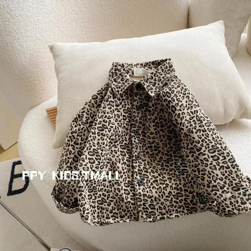 A black and beige leopard print denim shirt worn casually on a white sofa.