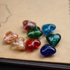 Collection de perles en verre filé forme cœur, coloris scintillants rose, vert, bleu et rouge sur fond blanc