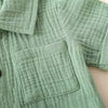 A close-up of a sage green linen toddler shirt with a chest pocket.