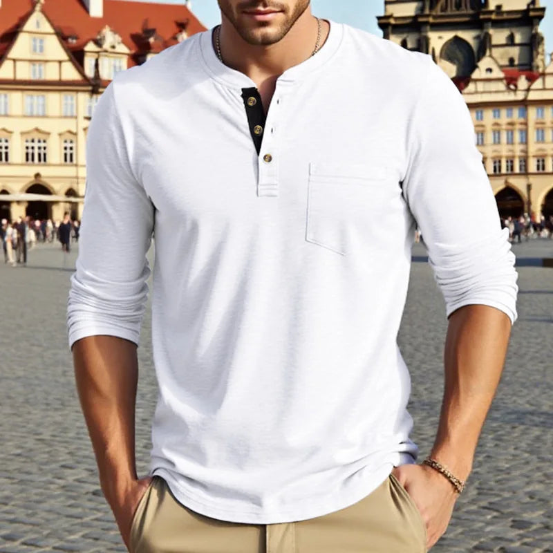 A man wearing a white long-sleeve casual shirt with a collar and chest pocket, standing outdoors.