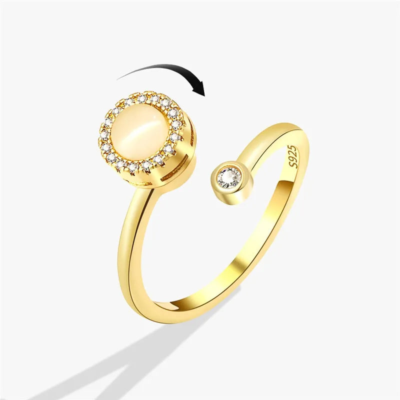 Närbild på en guldtonad ring med fjärilsdesign och klara stenar, mot vit bakgrund.